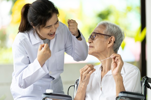 Asian senior woman listen,study how to use dental floss with professional female dentist,service or educate about oral health care,gums treat,teach teeth cleaning hygiene while visiting a nursing home