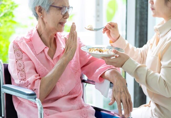 Elderly woman rejecting food, no appetite.