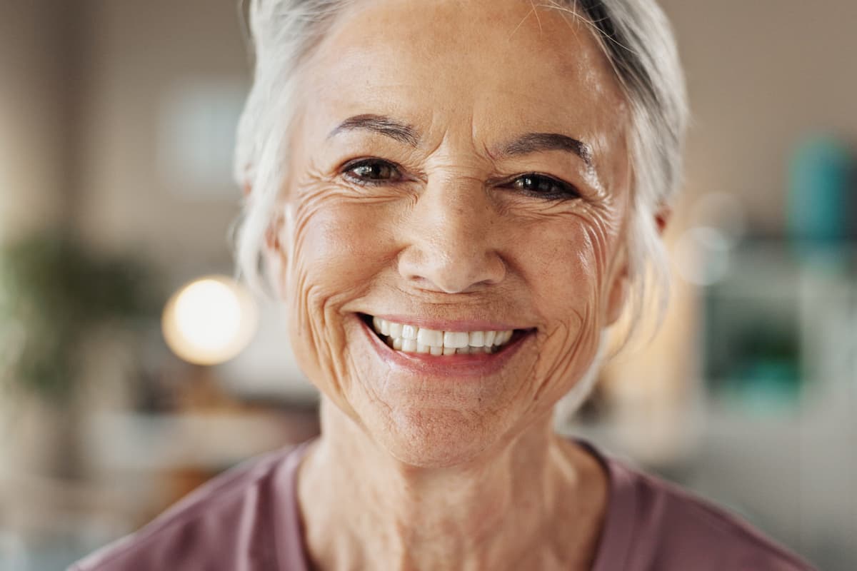 teeth-cleaning-happy-customer Smiling elderly woman after mobile teeth cleaning treatment at home.
